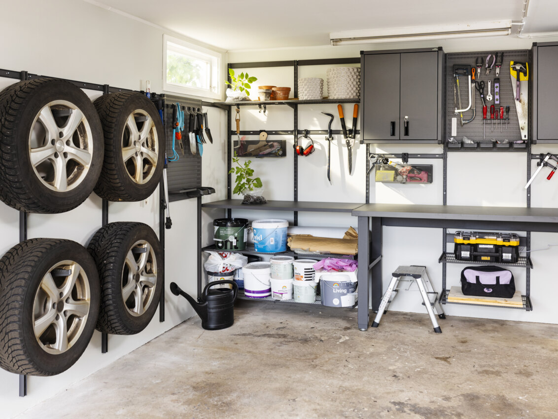 Garage med förvaring från Garage+ by Elfa där det förvaras däck, trädgårdsredskap och verktyg.