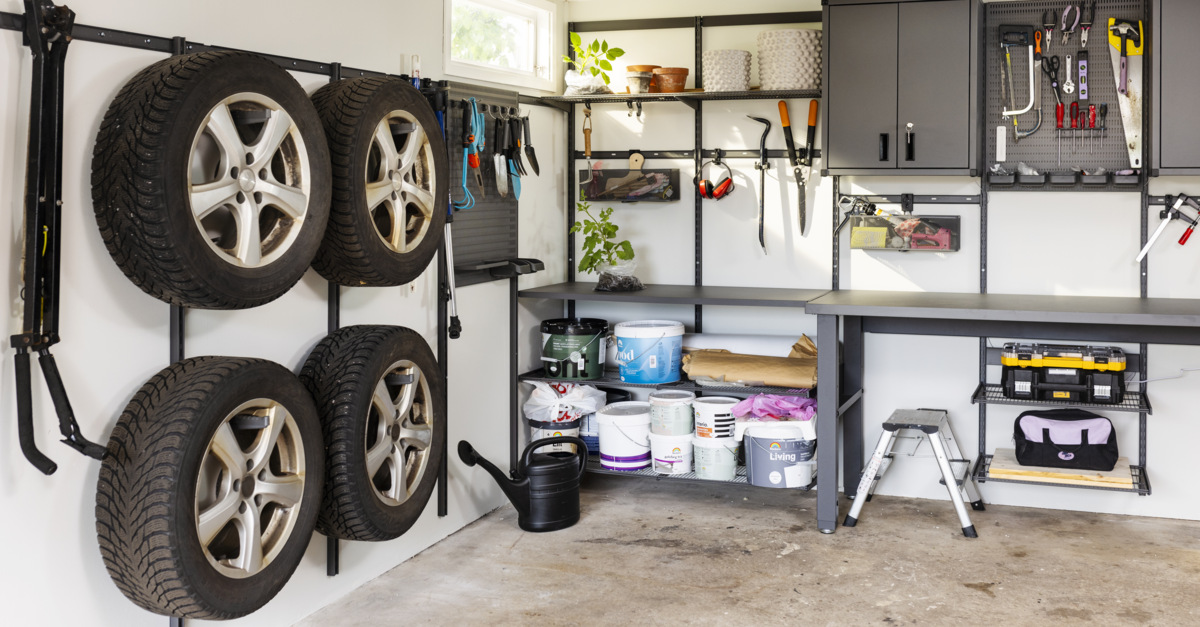 Garage med förvaring från Garage+ by Elfa där det förvaras däck, trädgårdsredskap och verktyg.