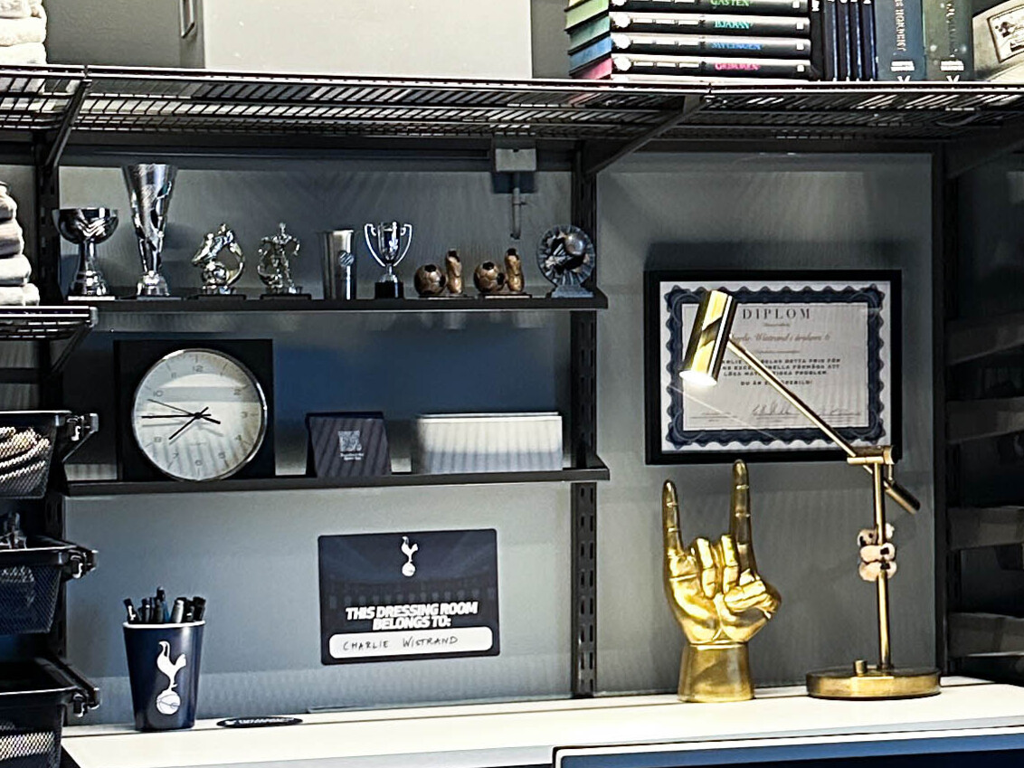 Skrivbord i ett tonårsrum med små trofér och andra prydnader. 