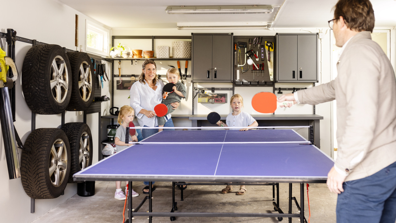 En familj spelar pingis i ett garage med förvaring från Garage+ by Elfa.