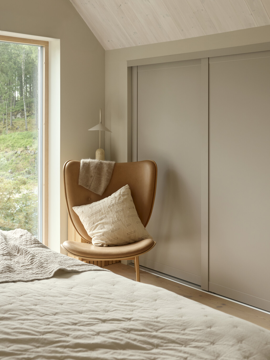 Sovrum med Elfa garderob som har skjutdörrarna Grace med fyllningen sandbeige.