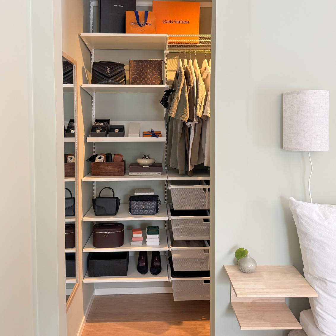 Sovrum med en walk-in closet från Elfa med skor, väskor och andra accessoarer.