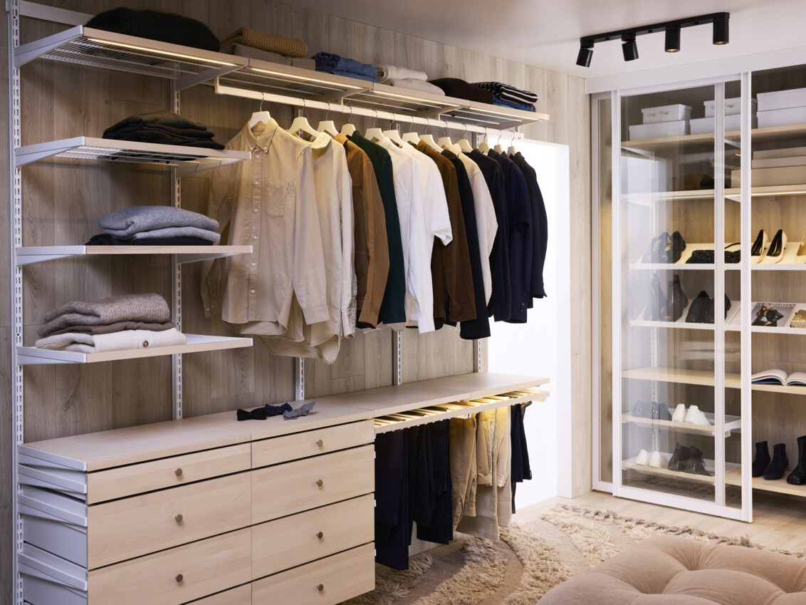 Walk-in closet från Elfa i björk med hängande kläder, lådor och byxhängare.