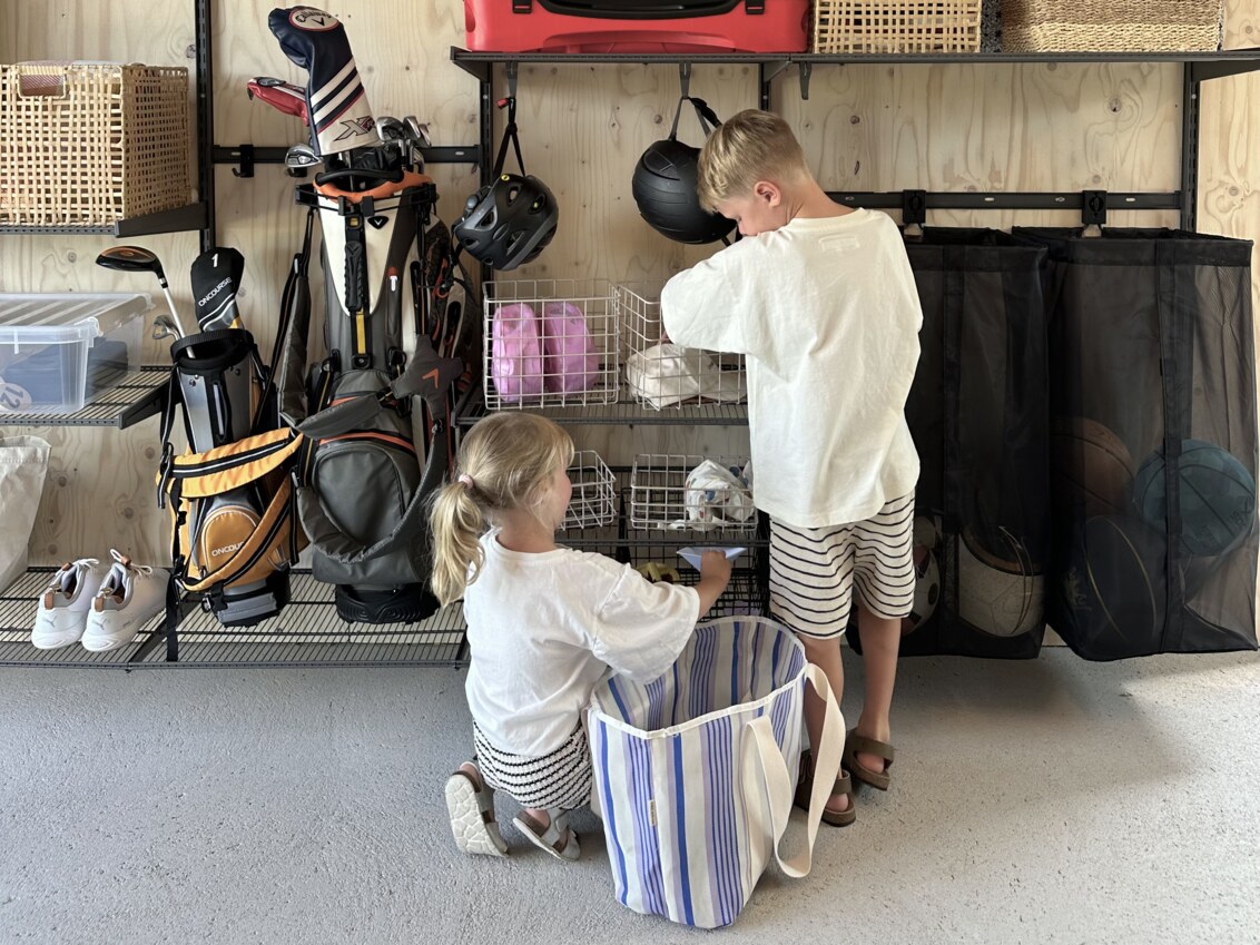Två barn hämtar ett par saker i ett garage med förvaring från Garage+ by Elfa.