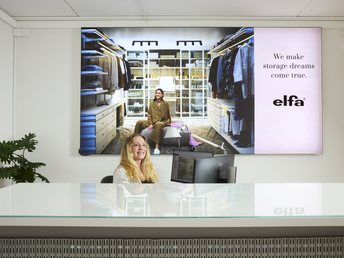 En kvinna sitter i receptionen på Studio Elfa Sisjön.