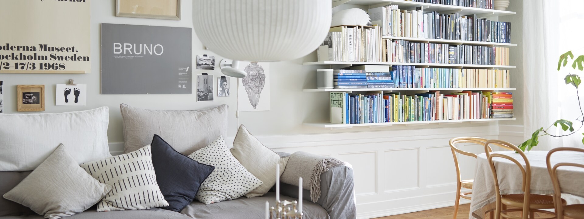 Olohuone, jossa on valkoinen Sparring by Elfa -kirjahylly, jossa kirjat on lajiteltu värien mukaan.