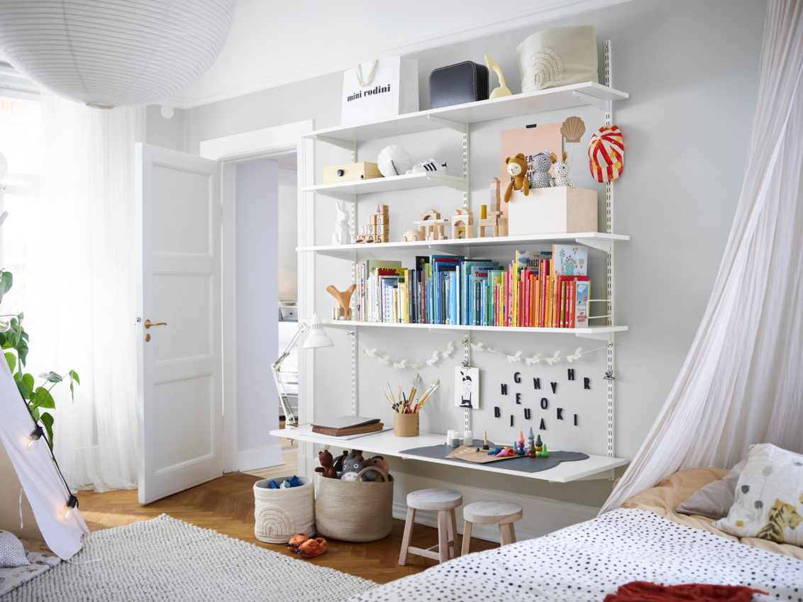 Lastenhuone, jossa on valkoinen Sparring by Elfa -kirjahylly, jonka alahylly toimii työpöytänä.