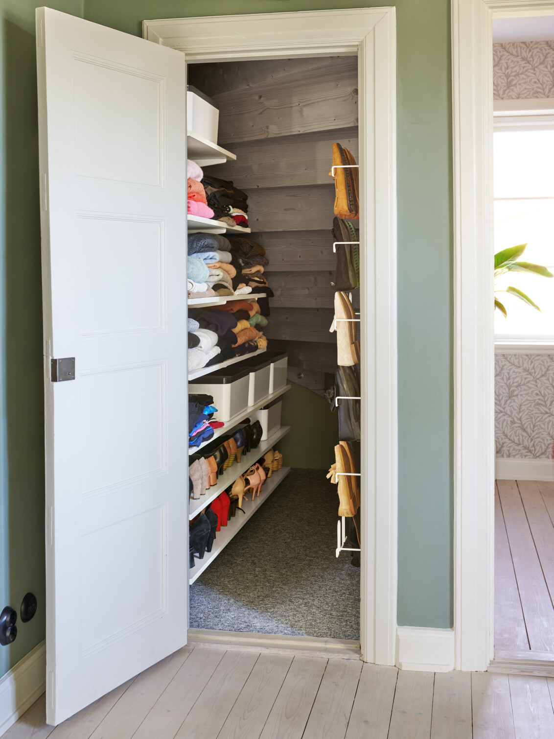 Förvaring från Elfa i ett förråd under en trappa.