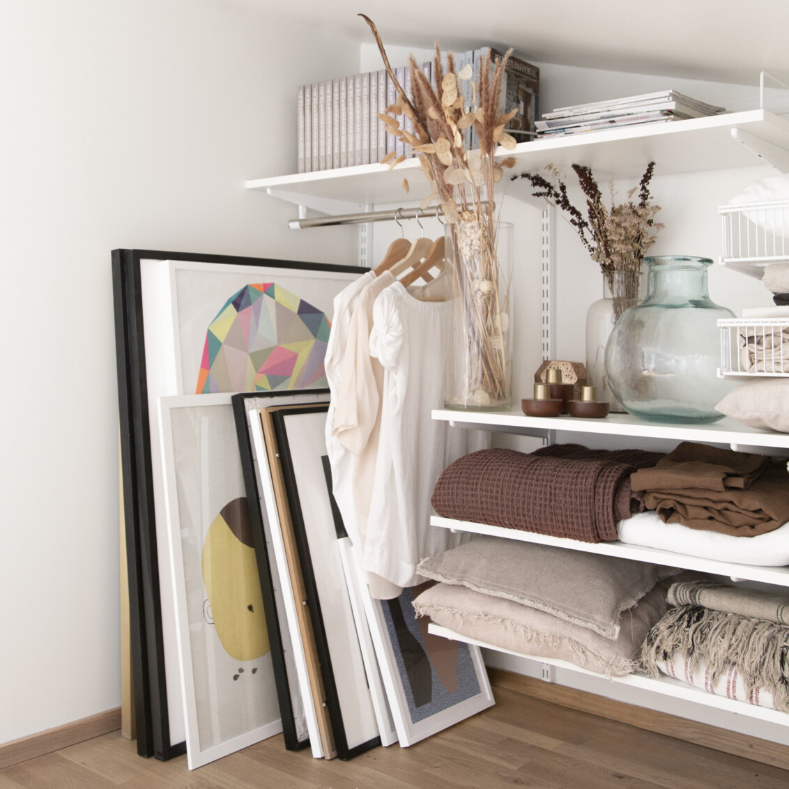 Vind med förvaring från Classic by Elfa där det förvaras tavlor, filtar och kläder.