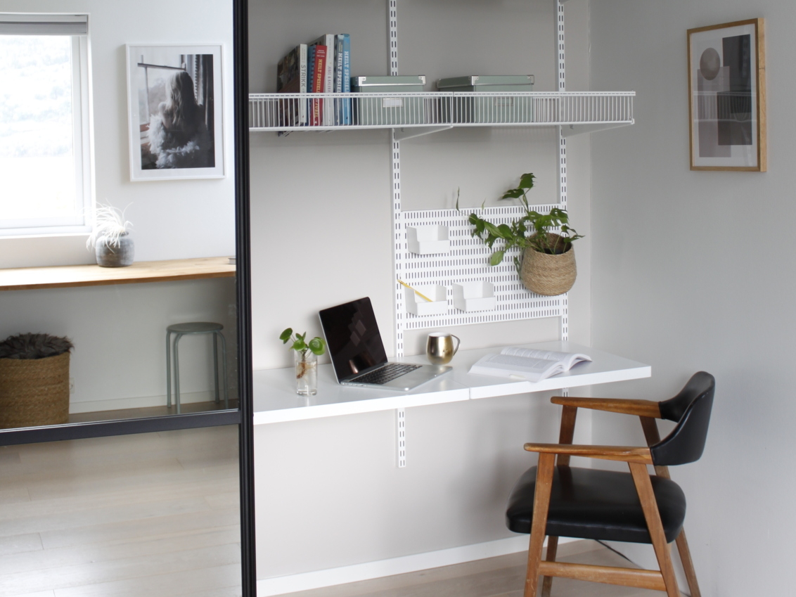 Kotitoimisto Classic by Elfa -säilytystilalla, jossa on lankakoreja, säilytystaulu ja melamiinihyllyjä liukuoven takana.