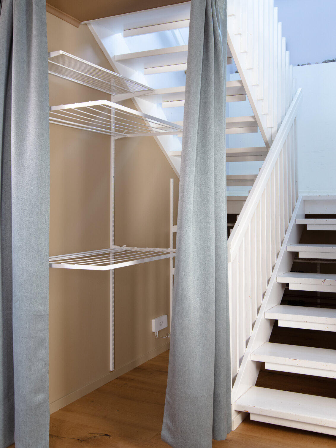 Området under trappen, hvor der hænger tørrestativer fra Elfa.