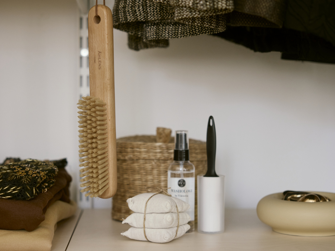 Klädvårdsprodukter i en öppen garderob från Décor+ by Elfa.