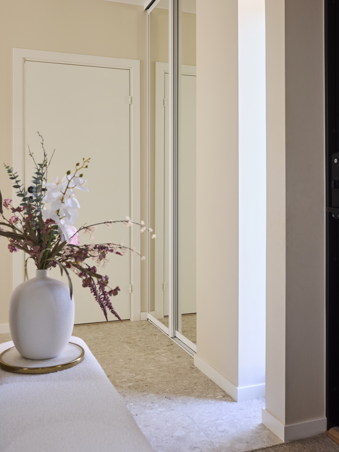 Przedpokój z szafą z drzwiami przesuwnymi Elfa z lustrem.