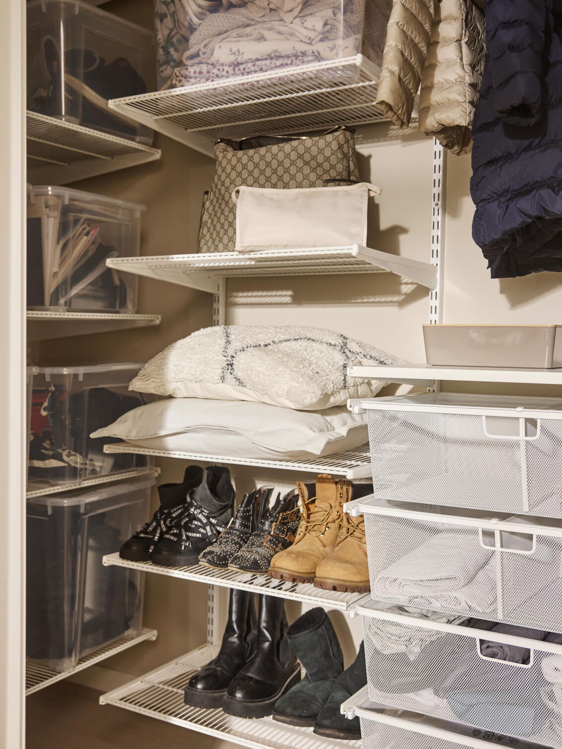 Oppbevaring med Classic by Elfa oppbevaring i hvitt der det oppbevares sko, yttertøy og puter.