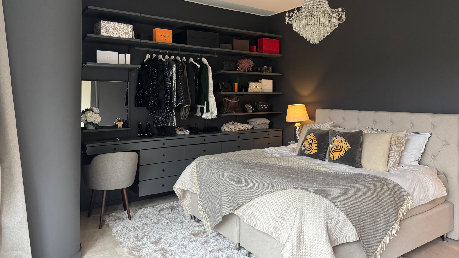 Sovrum med öppen garderob från Décor+ by Elfa i grått med hängande kläder och solida lådor.