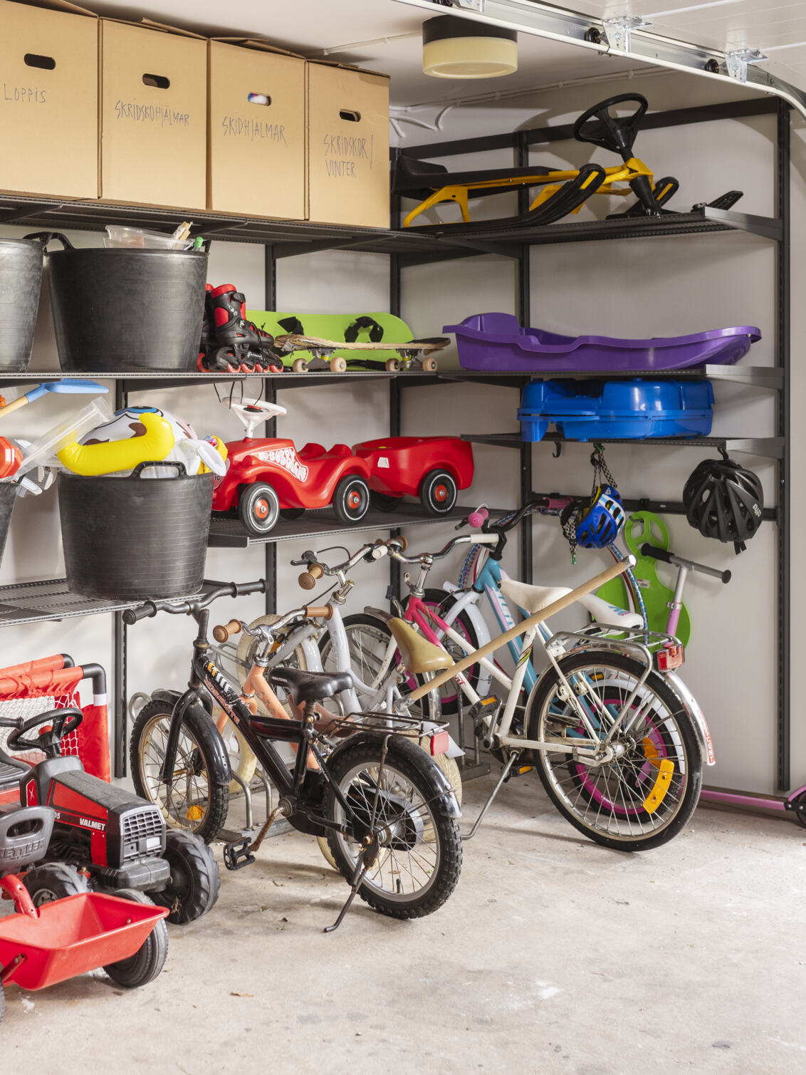 Garage med Garage+ förvaring från Elfa där det förvaras leksaker och barncyklar.