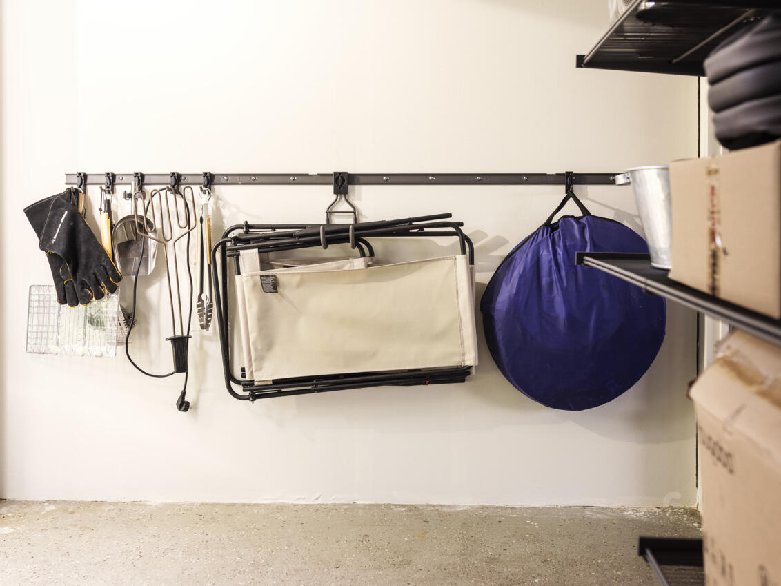 Garage with Garage+ storage track from Elfa used for hanging sun loungers and grill accessories.