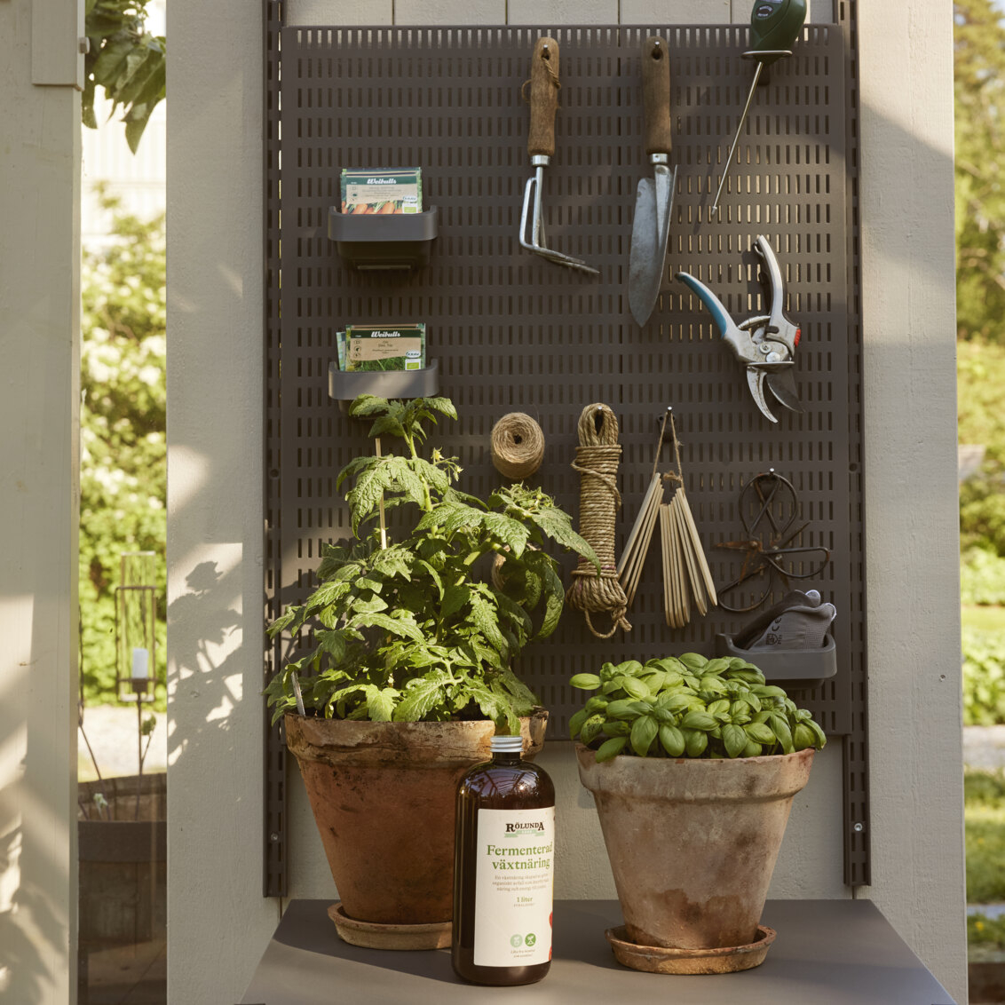 Garage+ oppbevaringstavle fra Elfa der det oppbevares hageredskaper.