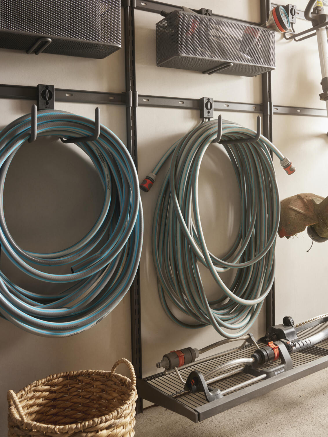 Garage+ oppbevaringslist fra Elfa der det henger hageslanger.