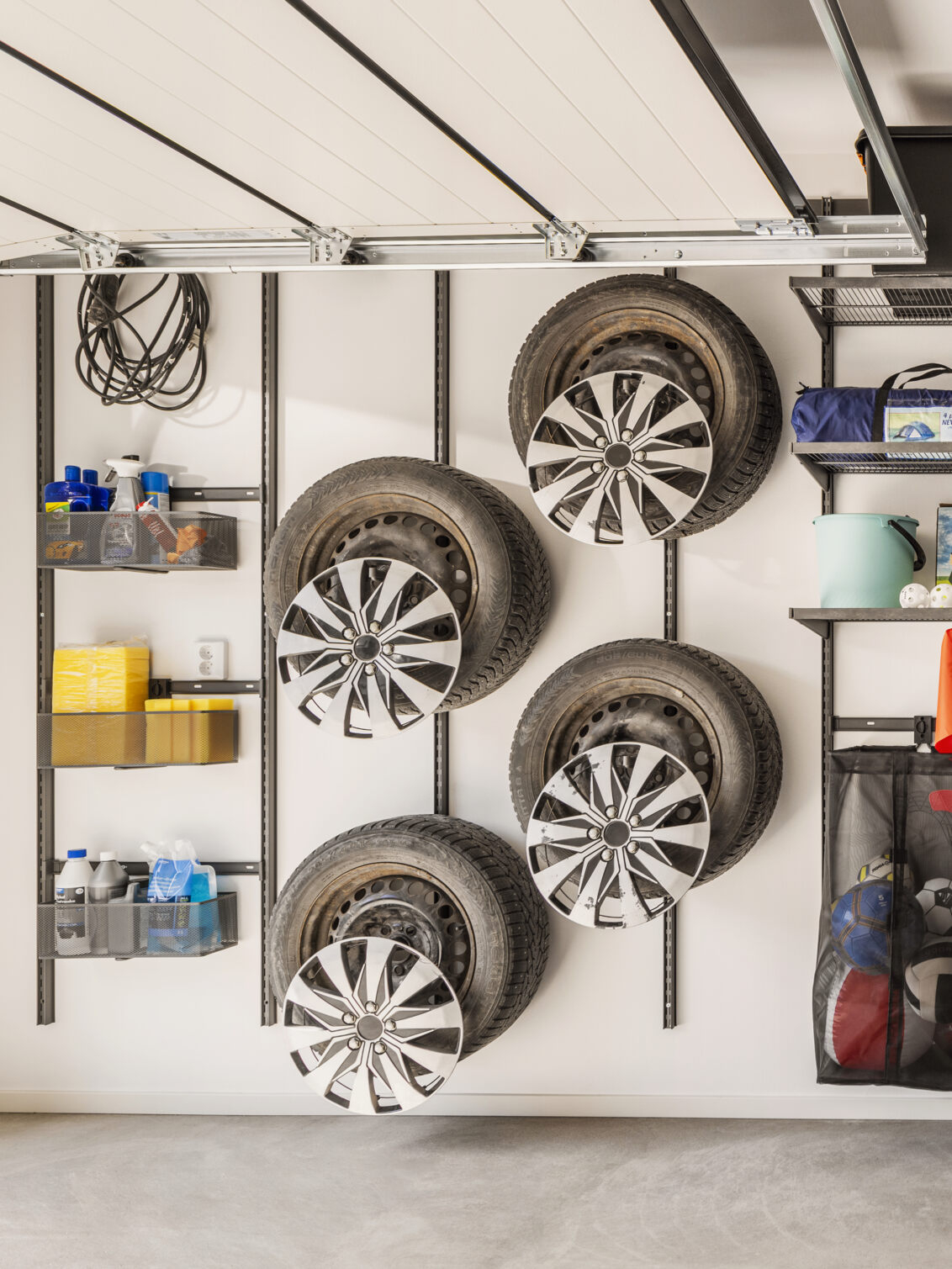 Garage with Garage+ by Elfa storage where car tyres hang on the wall.