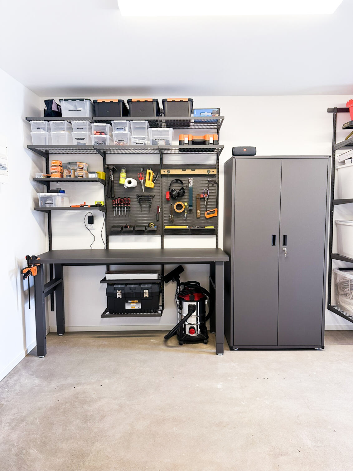 Garage with Garage+ by Elfa storage unit with workbench and cabinet for storing tools.