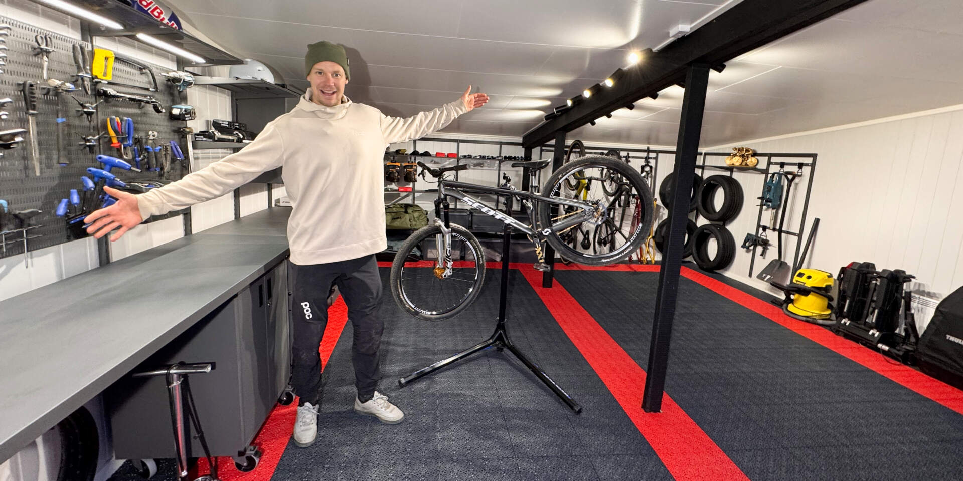 Martin Söderström i sitt garage med Garage+ by Elfa förvaring, med förvaringshyllor, arbetsbänkar, hyllor och skåp.