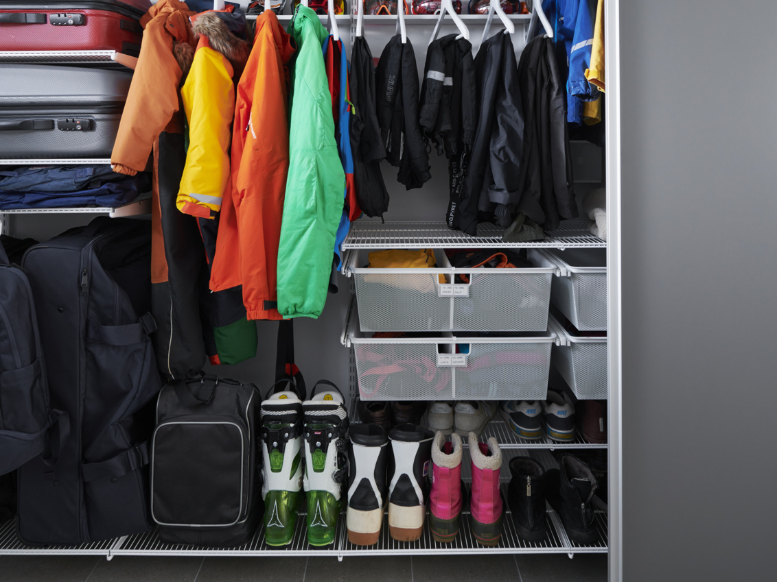 Graderob från Elfa med skjutdörrar i grått där det förvaras vinterkläder och skor.