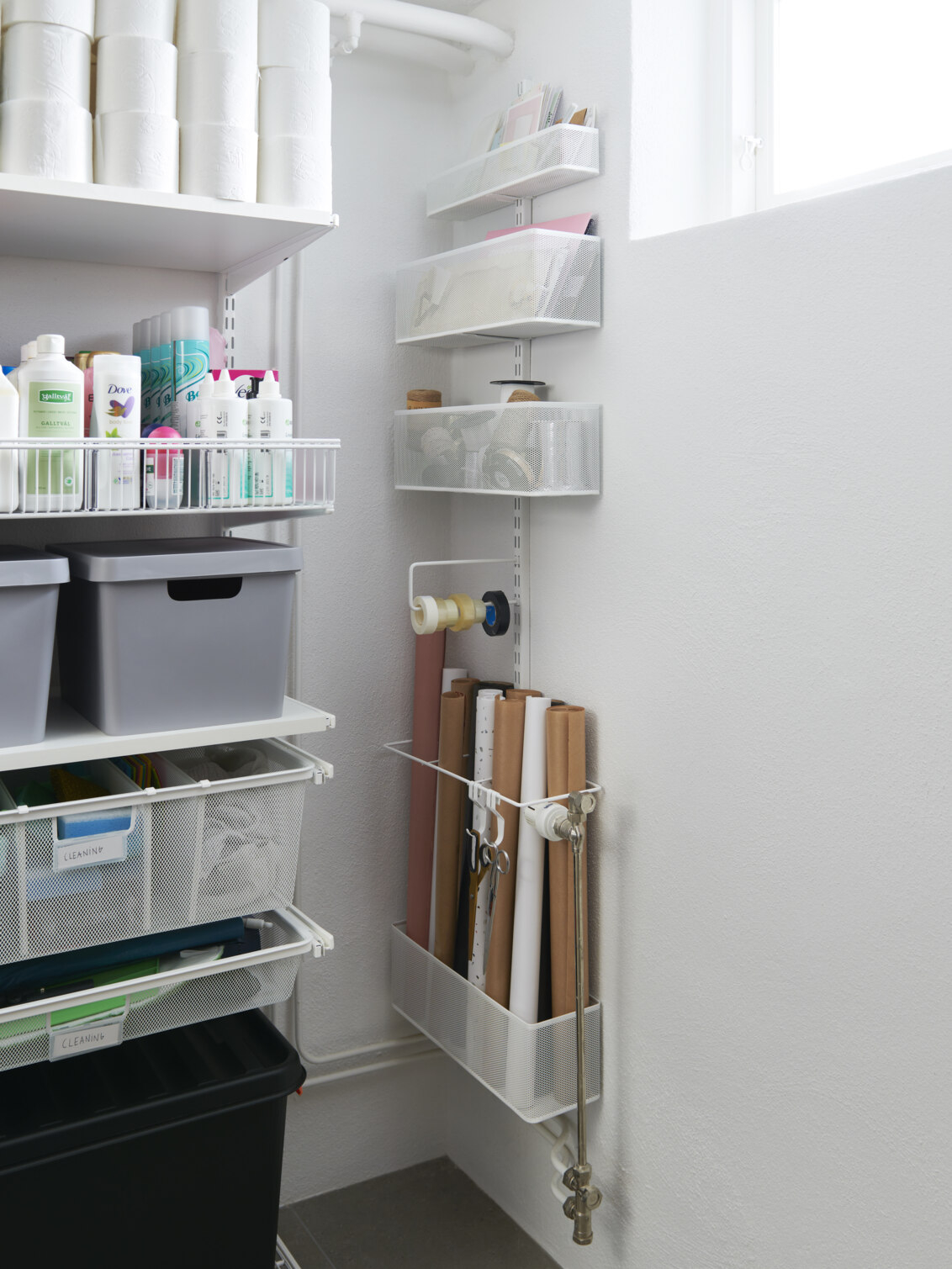 Ett hörn i källaren med förvaring från Elfa med meshkorgar där det förvaras presentpapper och pysselsaker.