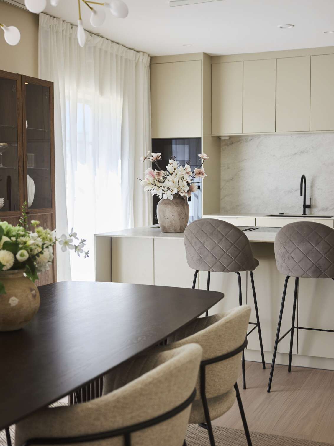 Kuchnia w jasnych odcieniach z blatem z ciemnego drewna.