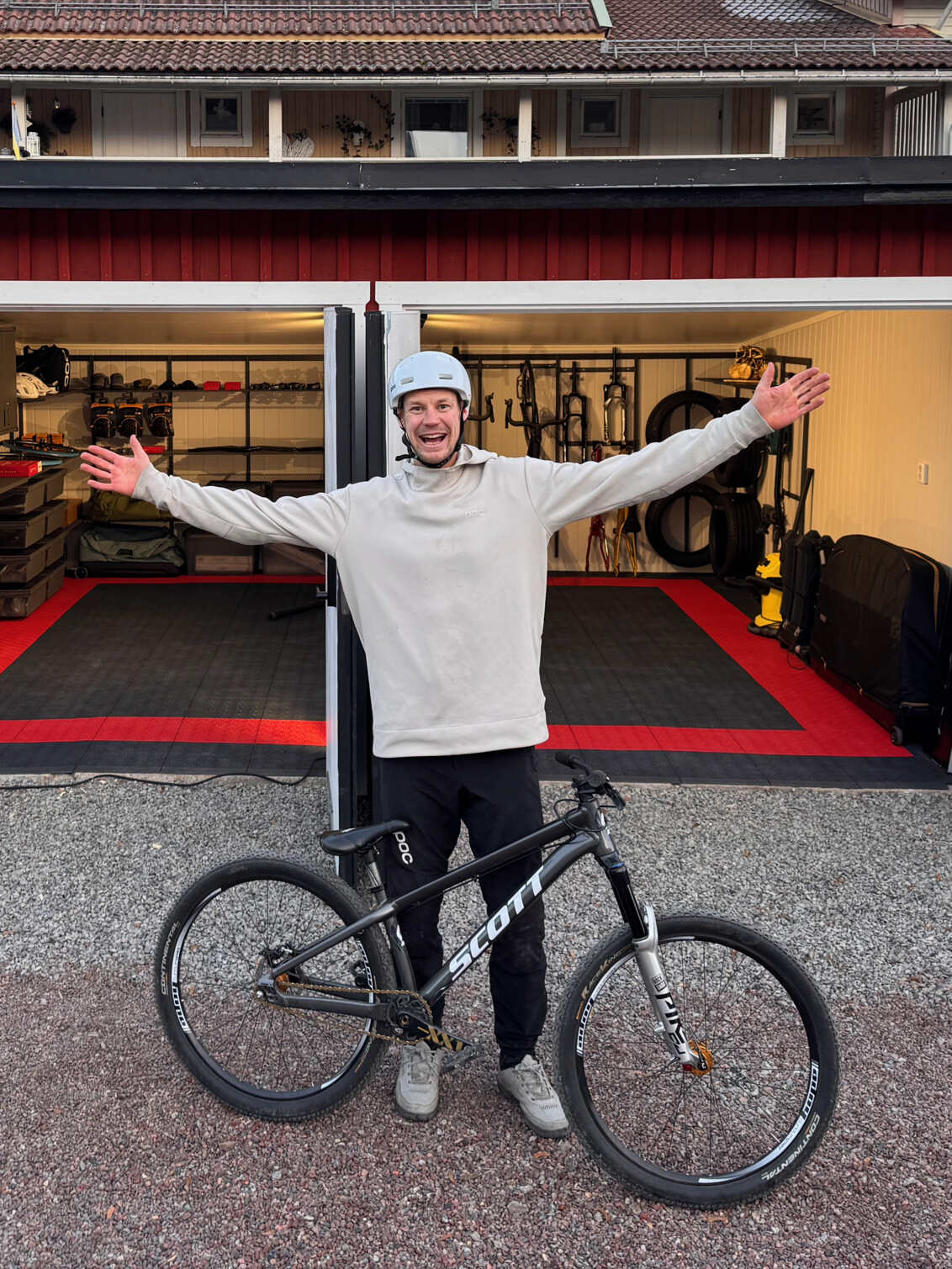 Martin Söderström utanför sitt garage som innehåller Garage+ by Elfa förvaring, som består av arbetsbänkar, skåp och backar.
