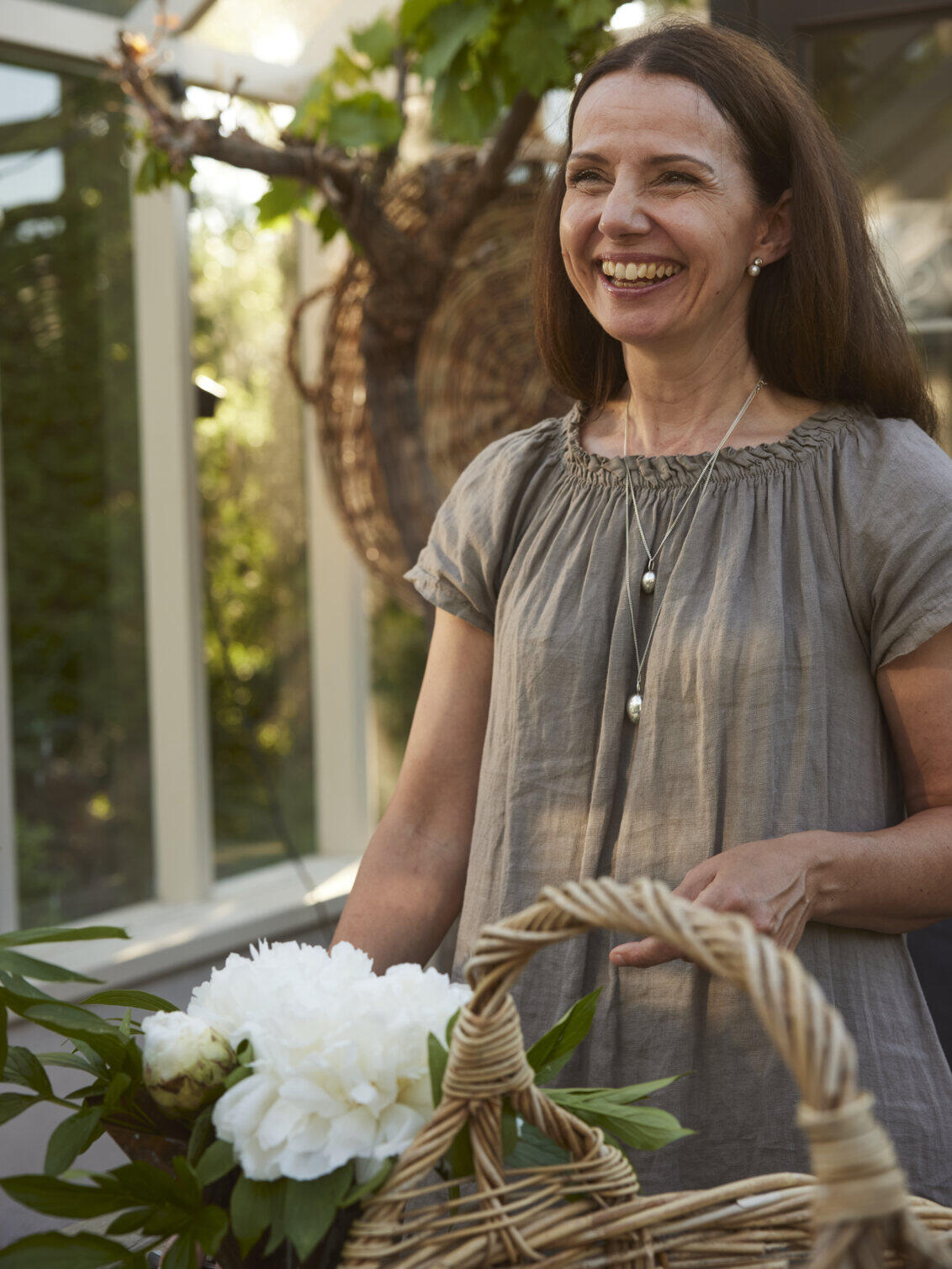 Carin is carrying a basket of white flowers.