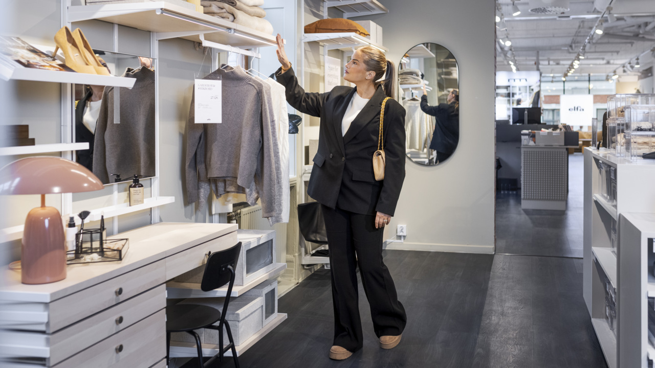 Ida-Marie tittar på en öppen gardeob i Studio Elfa.