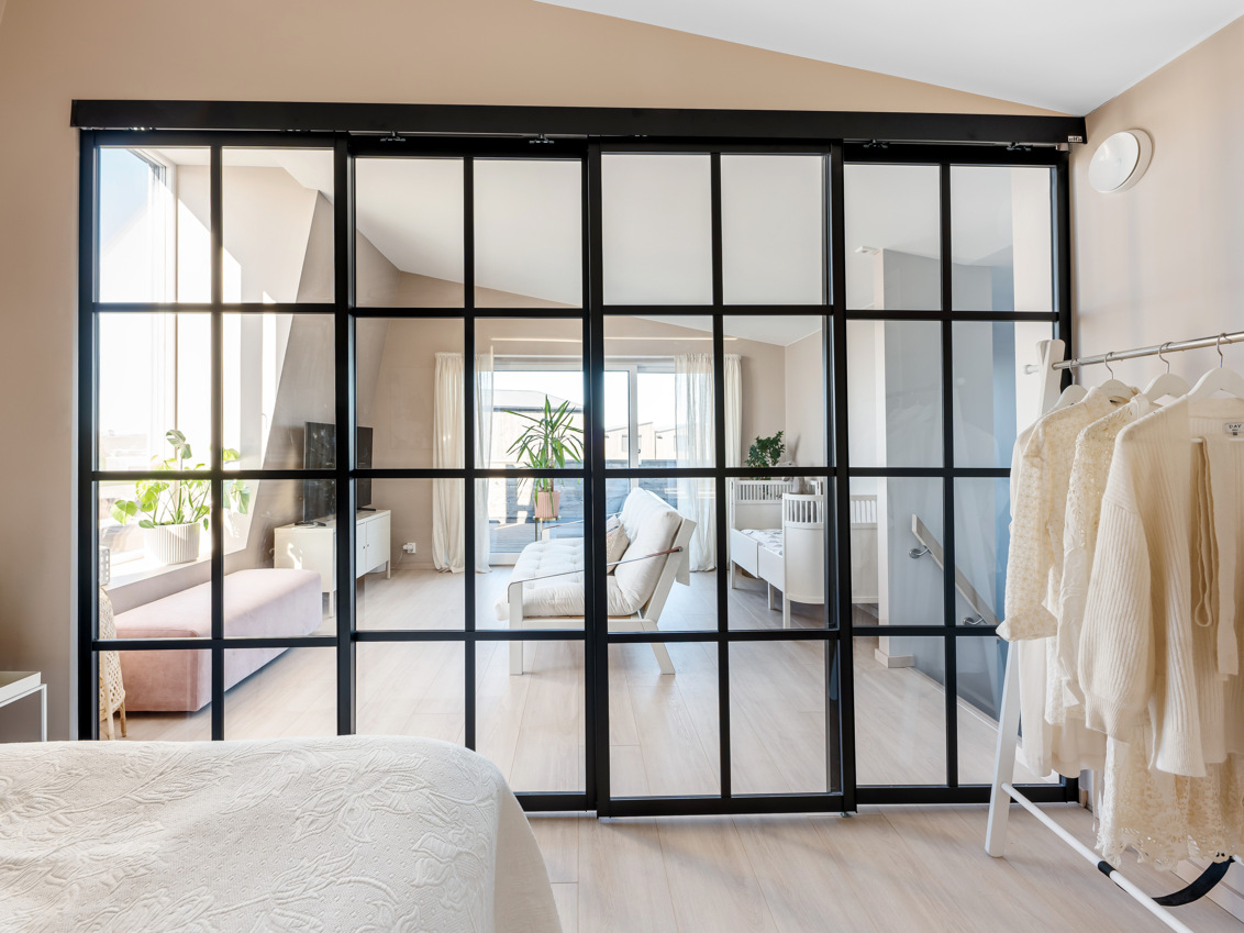 Tuuleta Elfan Artic-liukuovilla, joissa on mustat kehykset ja lasiset tilanjakajat.