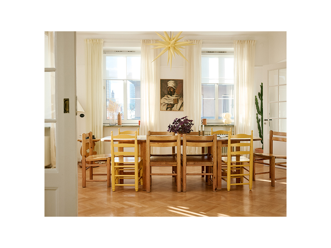 Matsalen hemma hos Emma och Saif, med höga fönster samt bord och stolar i massivt trä.