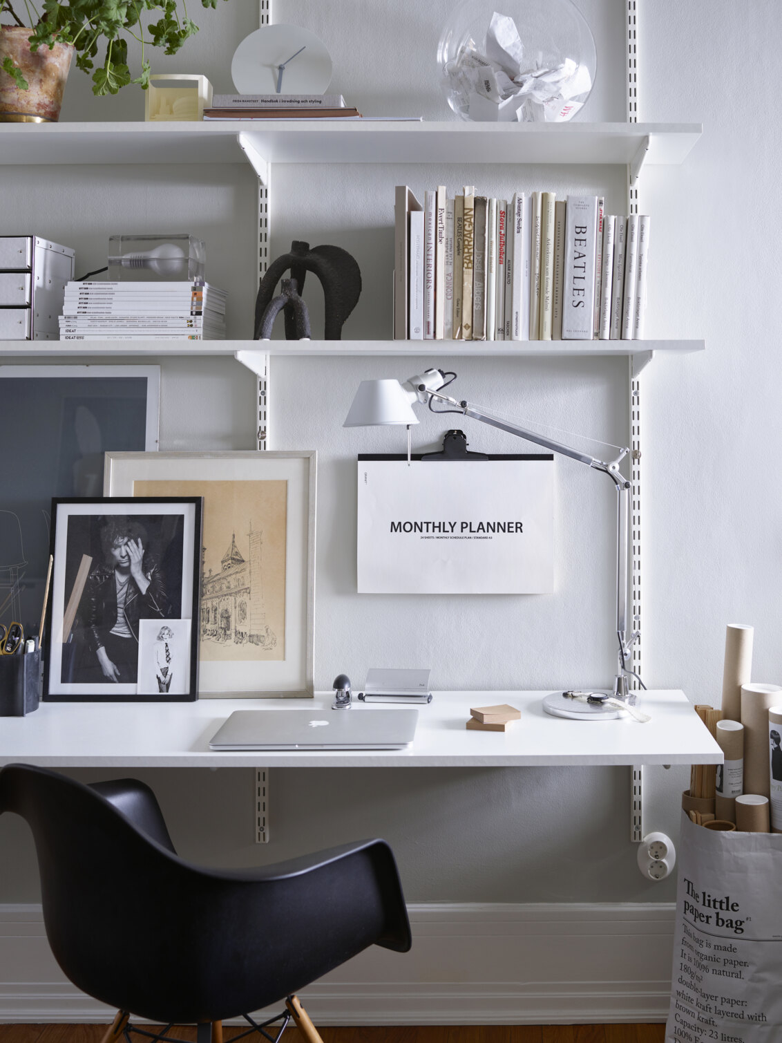 Kotitoimisto, jossa on Elfan perinteinen seinälle asennettava Sparring-hyllyjärjestelmä, musta toimistotuoli ja puujakkara.