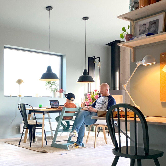 fjeldborg family Dining area with black ceiling lamps, wooden tables and colourful chairs in bright home