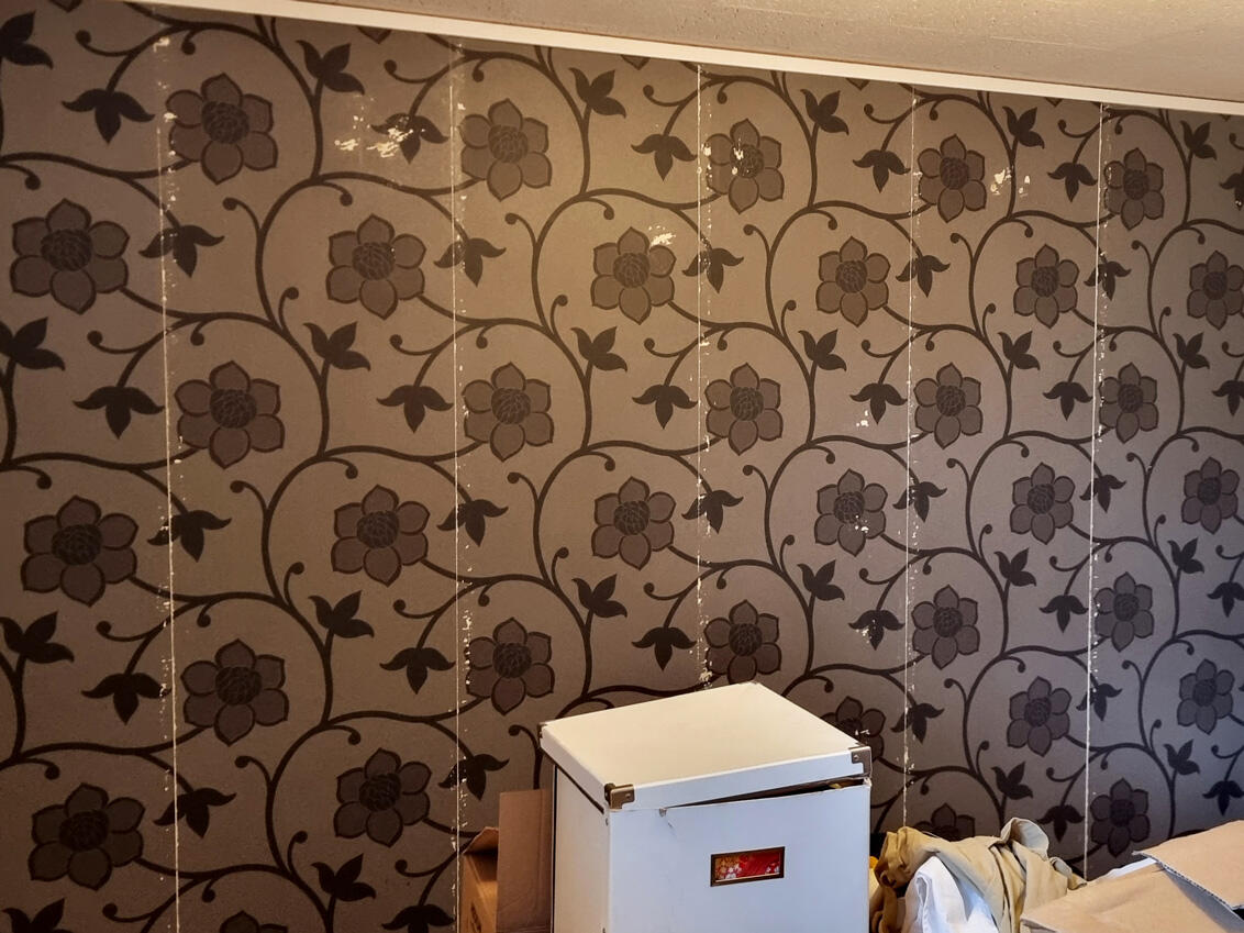 Blomstret tapet med midlertidige opbevaringsbokse før Elfa installation