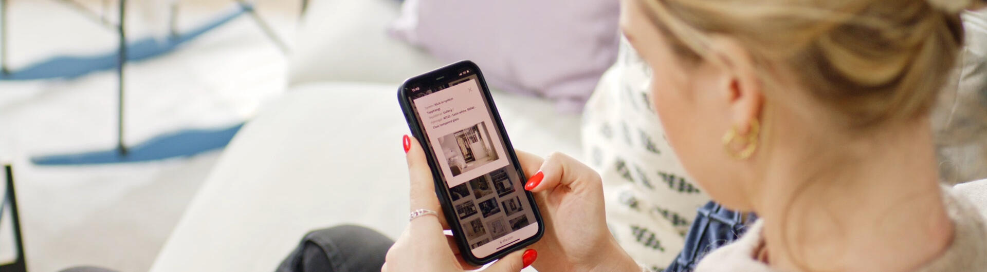 En kvinna tittar på Elfa produkter i mobilen
