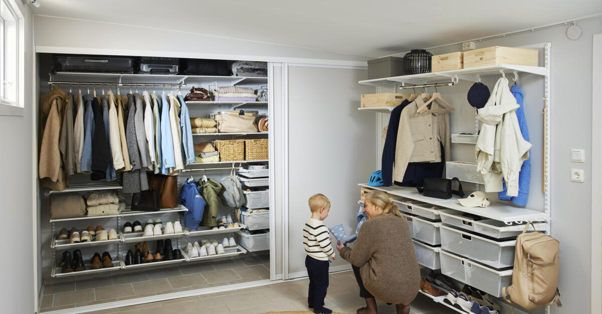 Äiti ja pieni poika eteisessä, jossa on Classic by Elfa -säilytyskaluste ja harmaat Artic-liukuovet.