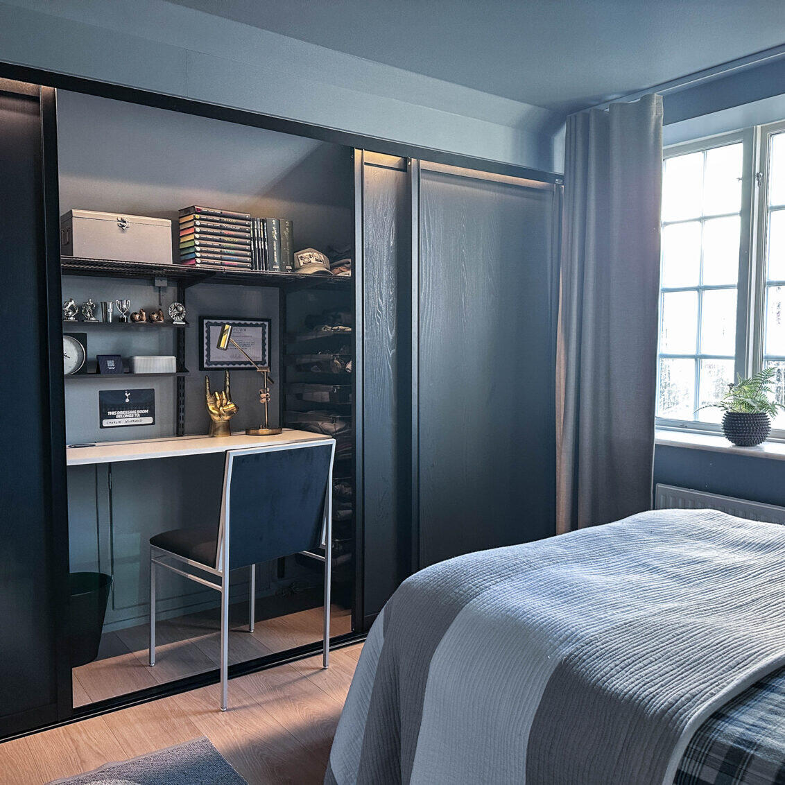 Tenåringsrom med skrivebord og klesoppbevaring fra Elfa bak skyvedørene Artic i svart.