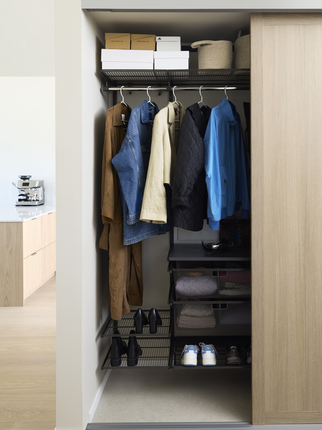 Hall med Elfa garderobe som har skyvedørene Grace med fyllet lys eik.