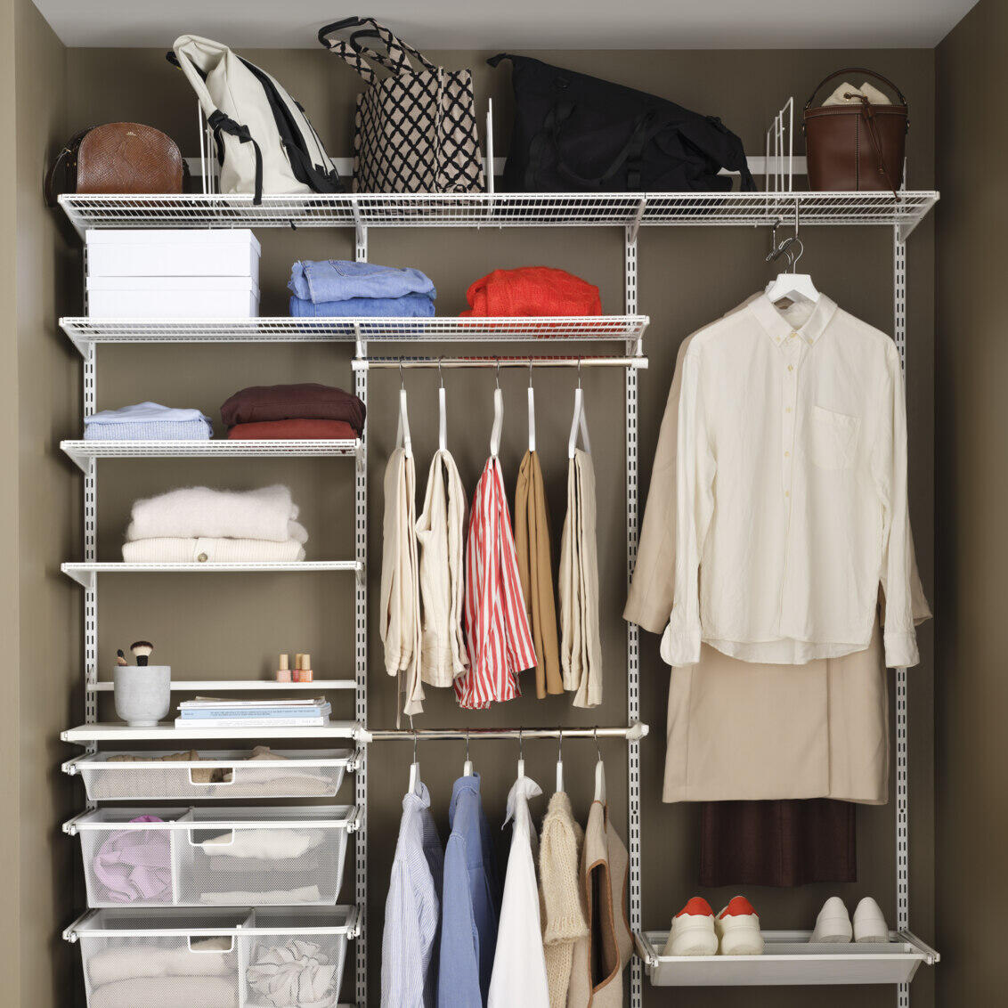 Otevřená šatní skříň od Elfy s drátěnými policemi, výsuvnými síťovanými zásuvkami, věšivými oděvy a botníky.