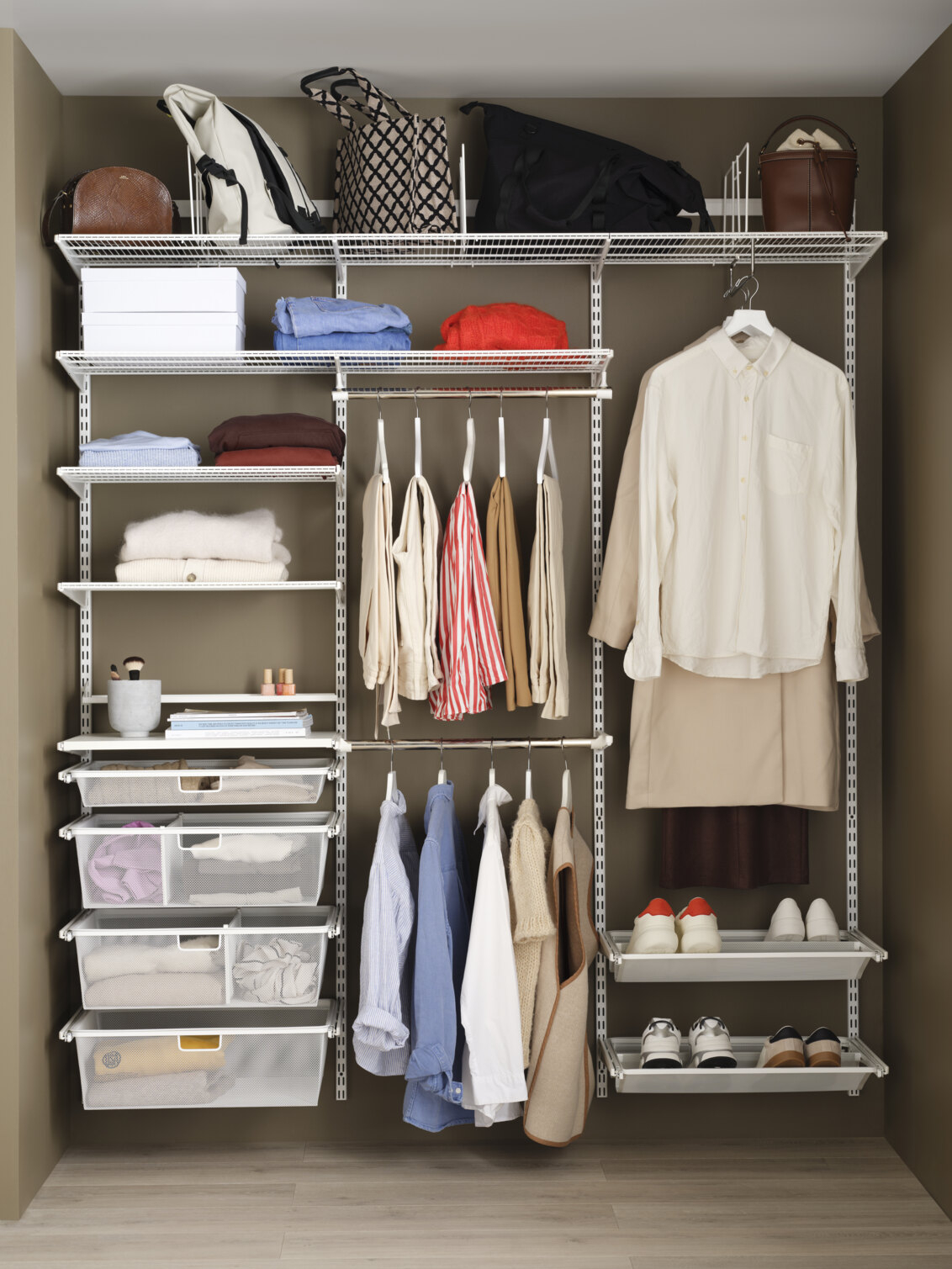 Öppen garderob från Elfa med trådhyllor, utdragbara meshbackar, hängande kläder och skohyllor.