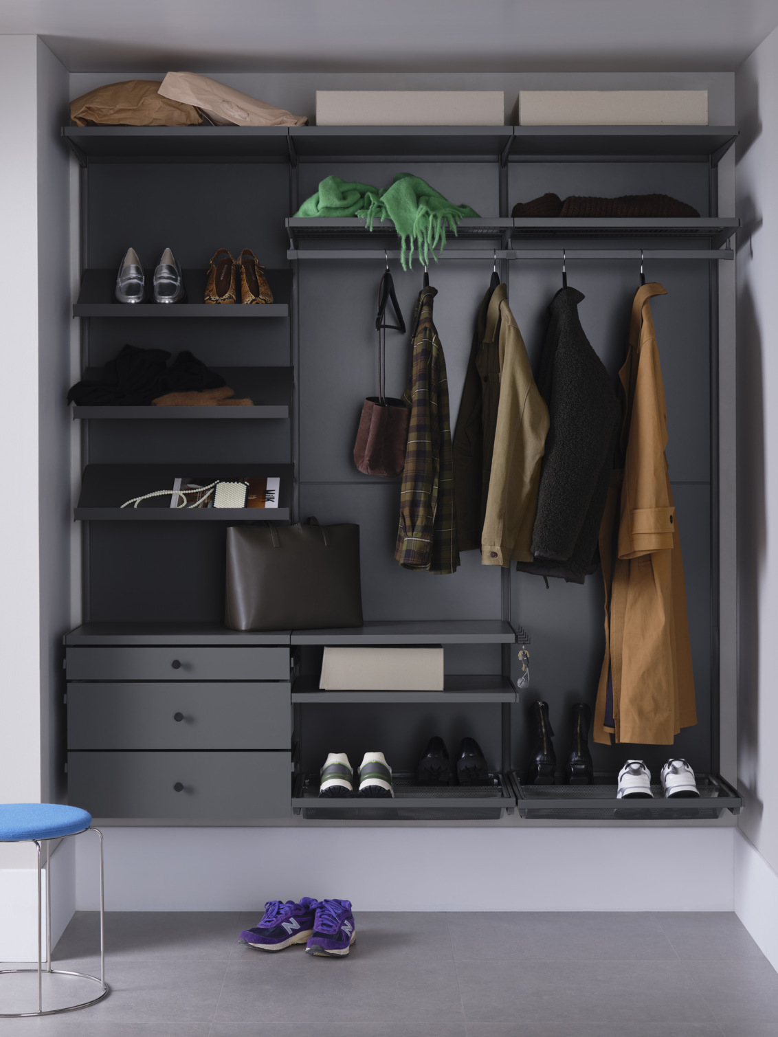 Couloir avec garde-robe Décor+ gris avec étagères, tiroirs et vêtements suspendus.