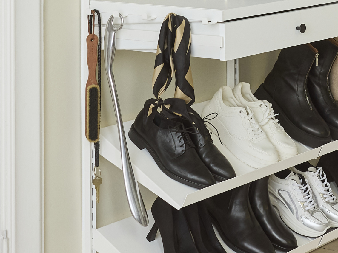 Tragarmaufsatz von Décor+ by Elfa, an dem ein Schuhhorn, eine Schuhbürste und ein Schal hängen.