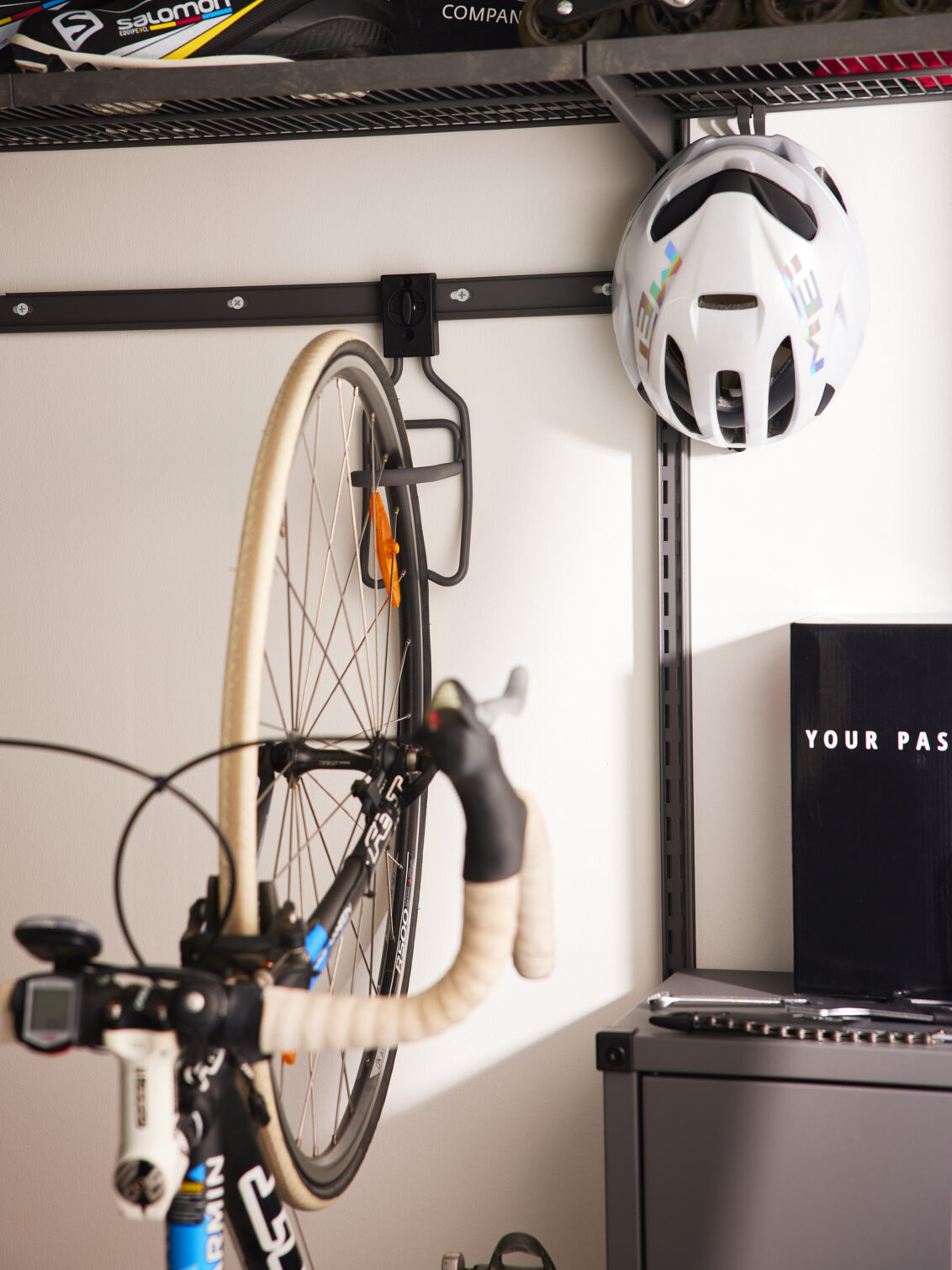 En cykel hänger i en vertikal cykelhållare från Garage+ by Elfa.