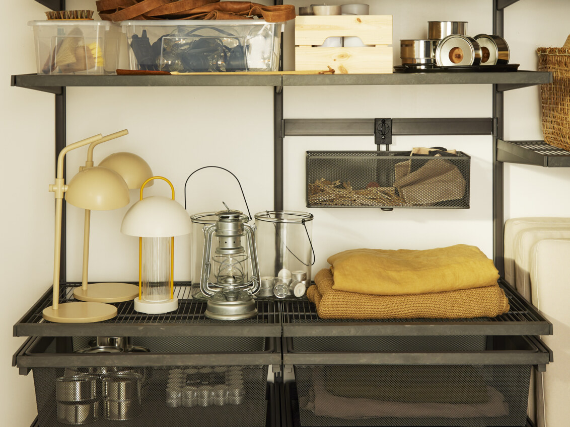 Un garaje con almacenamiento Garage+ de Elfa donde se guardan cojines, mantas, lámparas y cables.