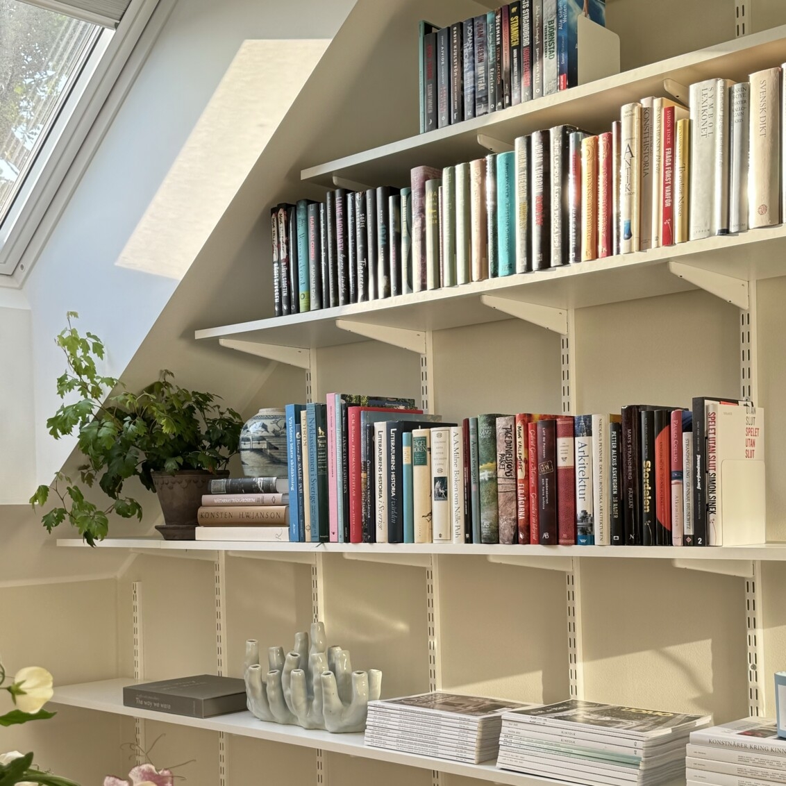 Sparring by Elfa bokhylla i vitt under ett snedtak.