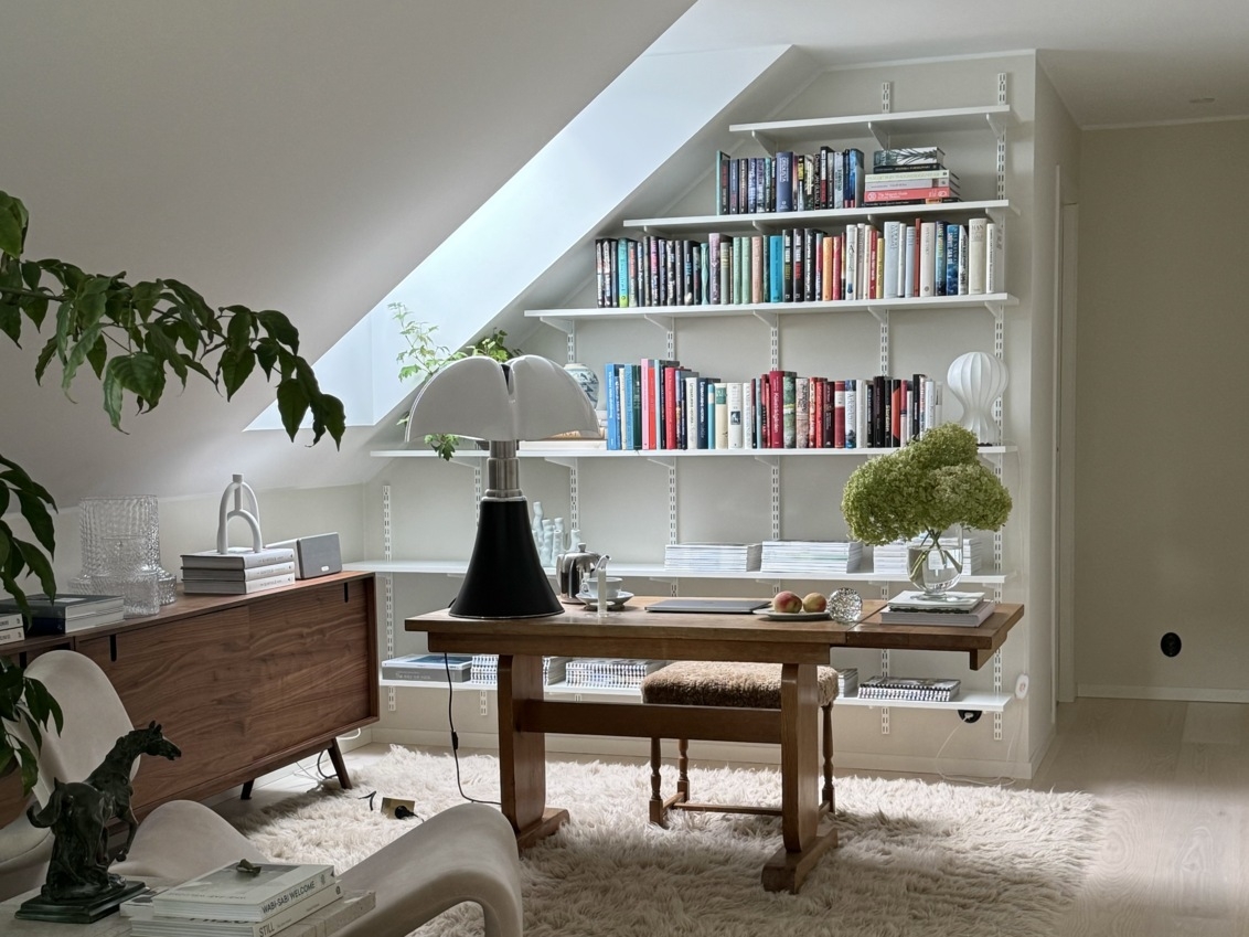 Kotitoimisto, jossa on valkoinen Sparring by Elfa -kirjahylly vinokaton alla.