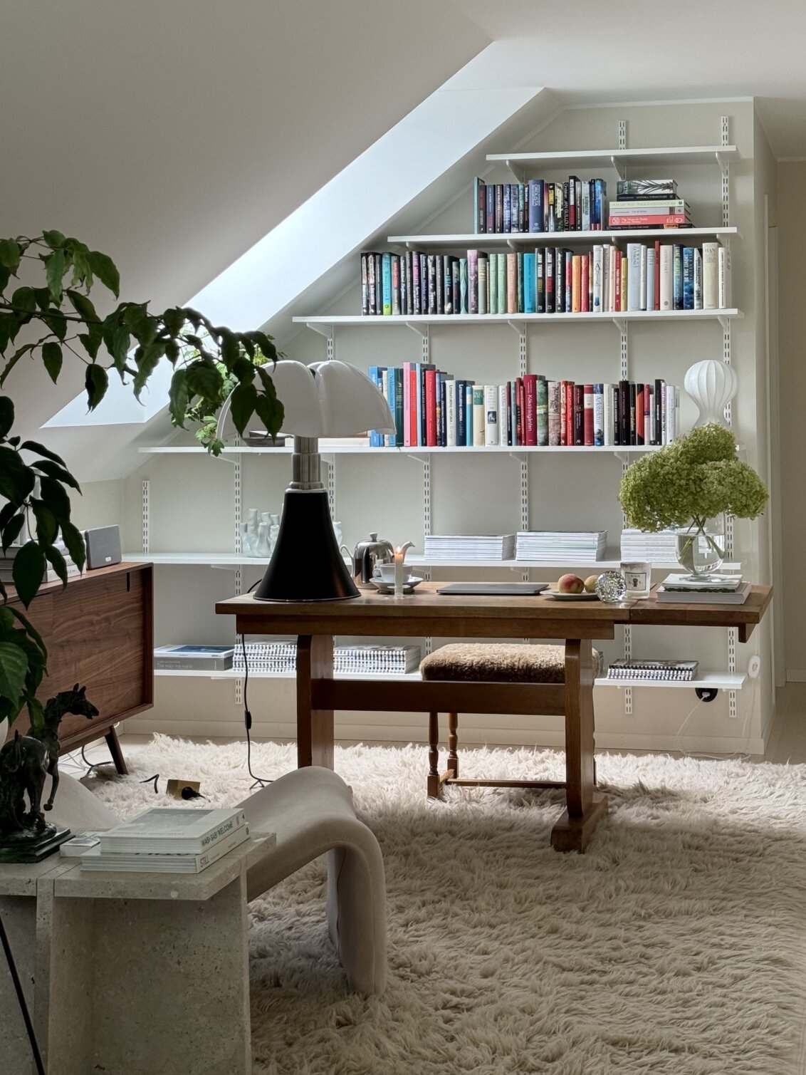 Hemmakontor med Sparring by Elfa bokhylla i vitt under ett snedtak.